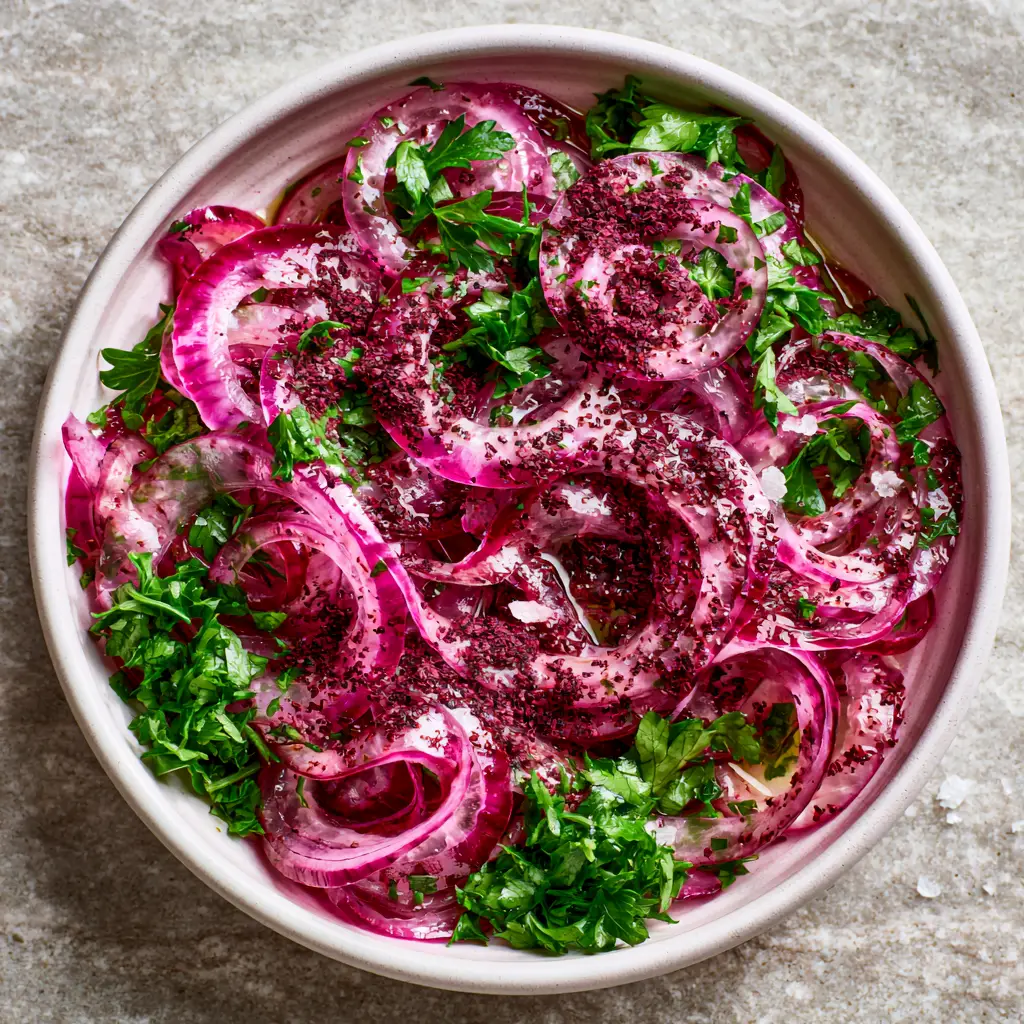 Sumac Onion Salad: The Vibrant Turkish Condiment for Your Favorite Dishes 1 Hyper-realistic view of a sumac onion salad garnished with bright emerald-green flat-leaf parsley on a stone surface.
