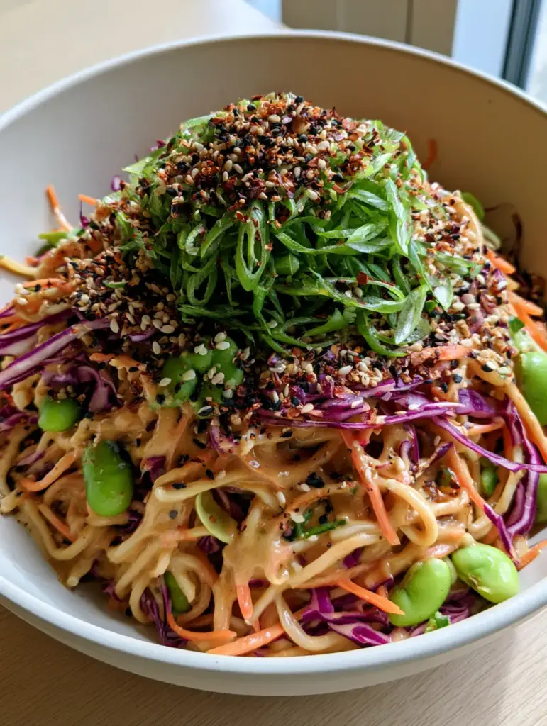 Sesame Noodle Salad: The Ultimate Creamy Cold Pasta Recipe 2 A close up overhead shot of a glossy sesame noodle salad with purple cabbage and edamame.