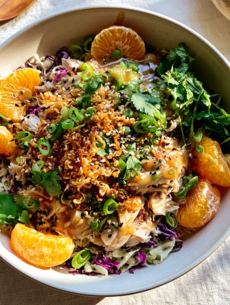 ramen Chinese chicken salad with Crispy Toasted Noodles 1 Close-up of toasted ramen noodles and black sesame seeds on a ramen Chinese chicken salad.