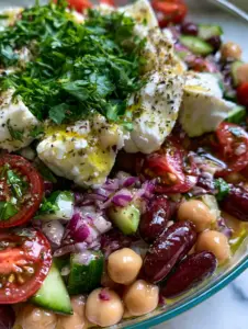 Hyper-realistic macro shot of glossy chickpeas, dark kidney beans, and rustic feta crumbles in a bean salad with feta.