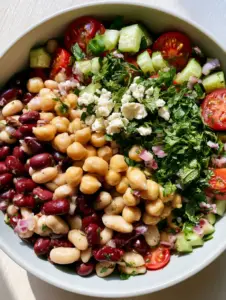 Macro shot of mixed bean salad featuring chickpeas, kidney beans, and fresh herbs. (mixed bean salad)