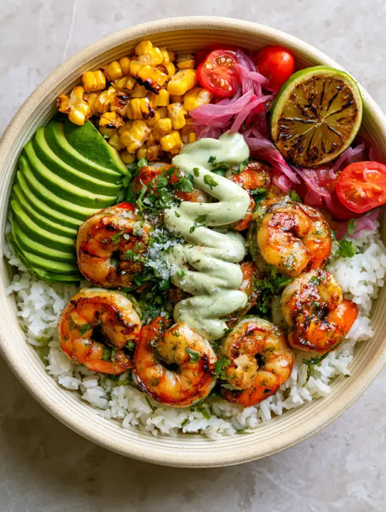 Grilled Shrimp Bowl Recipe with Cilantro Lime Crema 1 Close up of charred sweet corn, blistered cherry tomatoes, and pickled red onions in a grilled shrimp bowl.