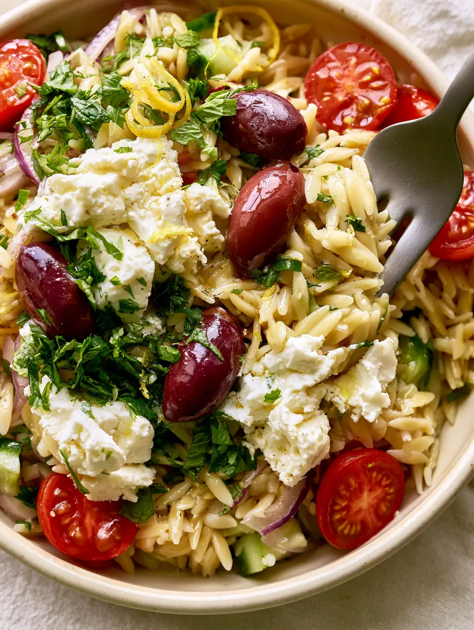 Close-up of Greek Orzo Pasta Salad showing individual glistening orzo grains and quartered cherry tomatoes.